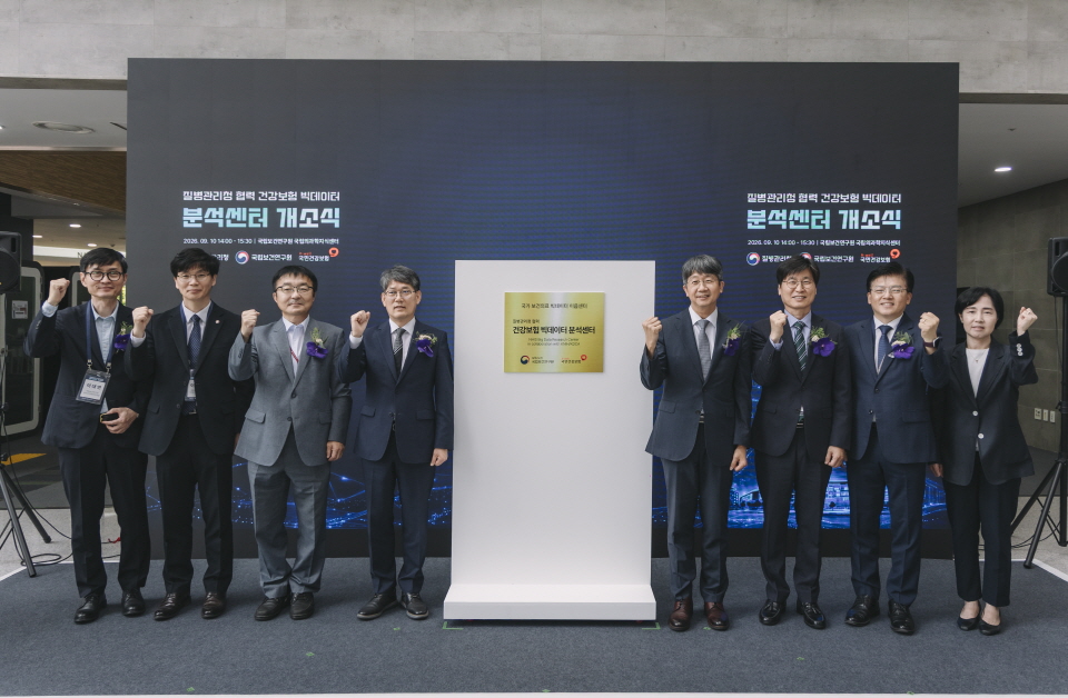 질병관리청 &middot; 국민건강보험공단의 주요 인사들이 빅데이터 분석센터 개소식에서 현판과 함께 기념촬영을 하고 있다.