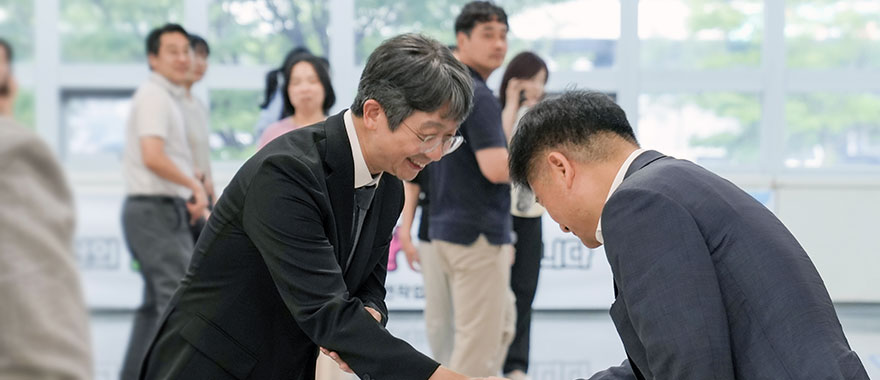  참석자와 웃으며 악수하는 청장님 사진